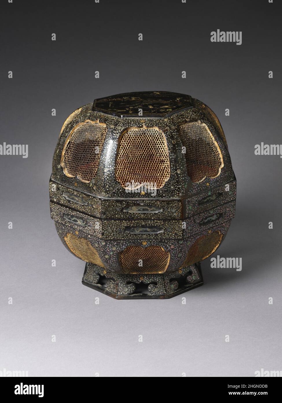 Boîte de nourriture octogonale avec des immortels chinois et de la conception florale 18th siècle Japon (Ry?ky?Îles, aujourd'hui préfecture d'Okinawa) cette boîte à nourriture octogonale vernie de noir richement décorée est dotée de panneaux encastrés sur chaque côté, incrustés de mailles métalliques dorées et entourée de motifs nacre incrustés de feuilles et de fleurs de pivoine.Les bords des sections supérieure et inférieure contiennent également de plus petits panneaux encastrés ornés de dragons en nacre incrustés.Le dessus plat de la couverture de la boîte est incrusté d'une conception de Shoulao, le Dieu chinois de la longévité, à cheval sur une grue AMO Banque D'Images