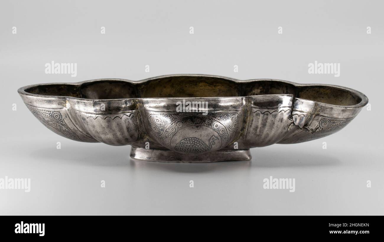 Bol à lobes ca.6th–7th Century A.D. Sasanian ce bol est en forme de bateau, avec de grands lobes aux extrémités et au milieu de chaque côté interspersonnés avec des plus petits.Les bords des lobes sont dorés, tout comme les intérieurs des quatre grands lobes.Les extérieurs des grands lobes sont décorés de guineafhibou (un proche parent du faisan) à l'intérieur de bordures rondes de motifs floraux et géométriques, qui sont incisés et remplis de niello.Les petits lobes sont dentelés.L'intérieur de la cuvette a une image d'un poisson avec une fée à fourche et quatre rangées d'échelles horizontales.Le poisson est probablement un saltwat Banque D'Images