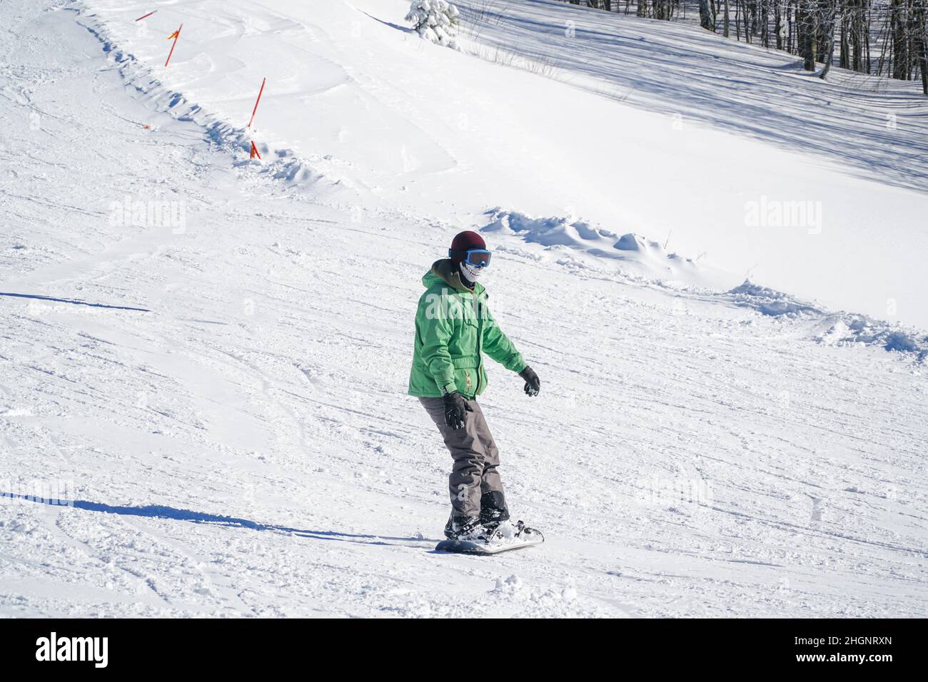 Homme dans des vêtements chauds snowboard freestyle de descente.Sports d'hiver.Sports extrêmes en hiver.Snowboardeur profitant de sports extrêmes en wi Banque D'Images