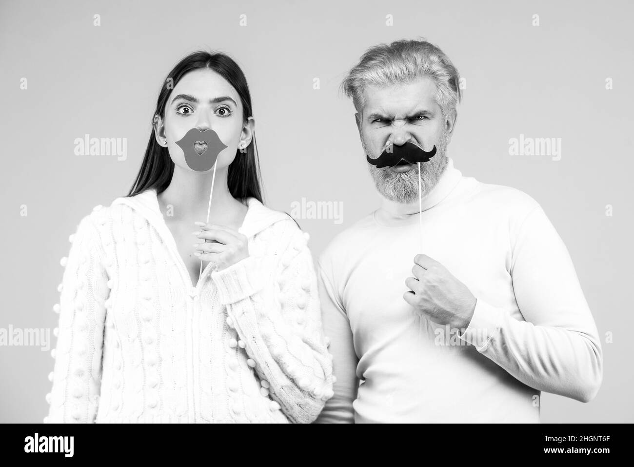Concept de cabine photo. Couple s'amusant avec la fausse moustache et les lèvres. Banque D'Images