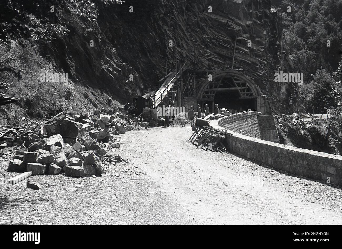 1950s, historique, estival et ouvriers sur une route de montagne effectuant des travaux de construction ou des réparations sur un tunnel, Pryenees, sud de la France. Banque D'Images