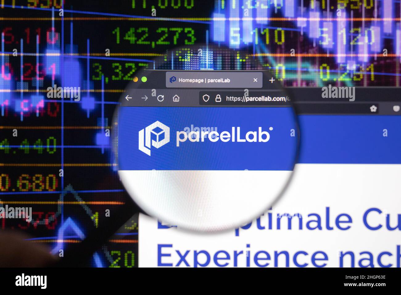 Le logo de la société Parcelllab sur un site web avec des développements flous du marché boursier en arrière-plan, vu sur un écran d'ordinateur à travers une loupe. Banque D'Images