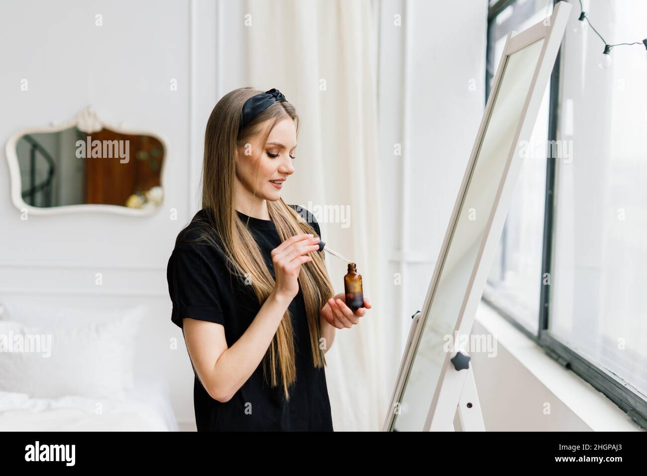 Belle dame qui fait le maquillage et les cheveux dans la chambre.Belle jeune femme avec des cheveux assez longs Banque D'Images