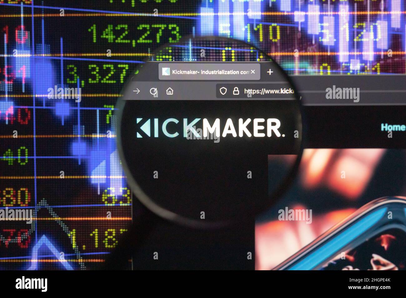 Logo de la société Kickmaker sur un site Web avec des développements flous du marché boursier en arrière-plan, vu sur un écran d'ordinateur à travers une loupe. Banque D'Images