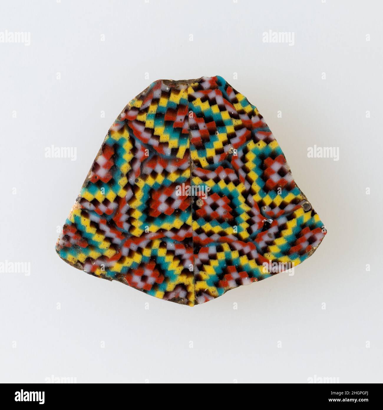 Fragment d'incrustation, petits carrés de couleur formant un motif de diamant 100 BC–100 AD période Ptoléméenne–période romaine Une technique de mosaïque de verre permet la création de multiples d'une image: Une composition figurale ou de dessin a été faite en regroupant des cannes de verre de couleur, qui ont ensuite été tirées dans une longue barre.La barre a ensuite été sectionnée à angle droit, probablement en frappant la barre avec les outils appropriés, pour produire de petits carreaux incrusts.Le carreau serait alors lissé et poli sur la face destinée à apparaître vers l'extérieur.Fragment d'incrustation, petits carrés colorés formant un motif en losange.100 BC–100 AD.Verre.Ptol Banque D'Images