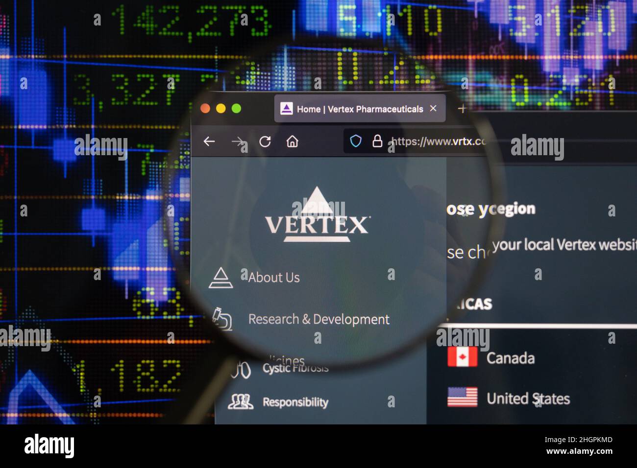Logo de la société Vertex sur un site Web avec des développements flous de marché boursier en arrière-plan, vu sur un écran d'ordinateur à travers une loupe. Banque D'Images