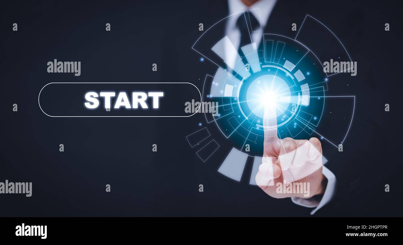 Homme d'affaires appuyez sur le bouton START future avec lumière virtuelle, bouton Start avec lumière spot sur fond bleu, en appuyant sur le bouton d'alimentation au-dessus de l'ordinateur.Démarrer Banque D'Images
