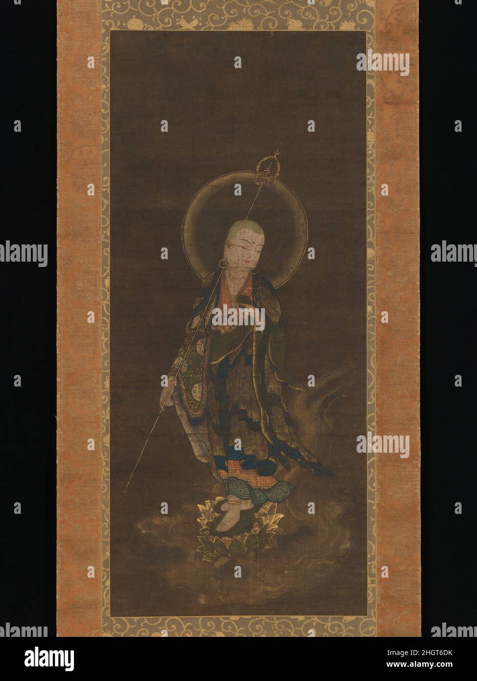 Mikaeri Jiz ?Bosatsu 14th siècle artiste non identifié le miséricordieux bodhisattva Jiz?(Sanskrit: Kshitigarbha) est montré menant une âme au paradis.Debout au sommet d'un nuage, avec son pied gauche en avant, un personnel doré tenu contre son épaule et portant des vêtements riches de motifs délicats en feuilles d'or coupées, il se tourne pour regarder son suiveur avec une légère vigilance.Populairement connu sous le nom de Mikaeri Jiz?(« Jiz?en regardant en arrière »), ce type d'image reflète avec force la foi dans les directives miséricordieuses de bodhisattva à travers les souffrances des six royaumes de l'existence (rokud?)Au bonheur du W de Bouddha d'Amida Banque D'Images