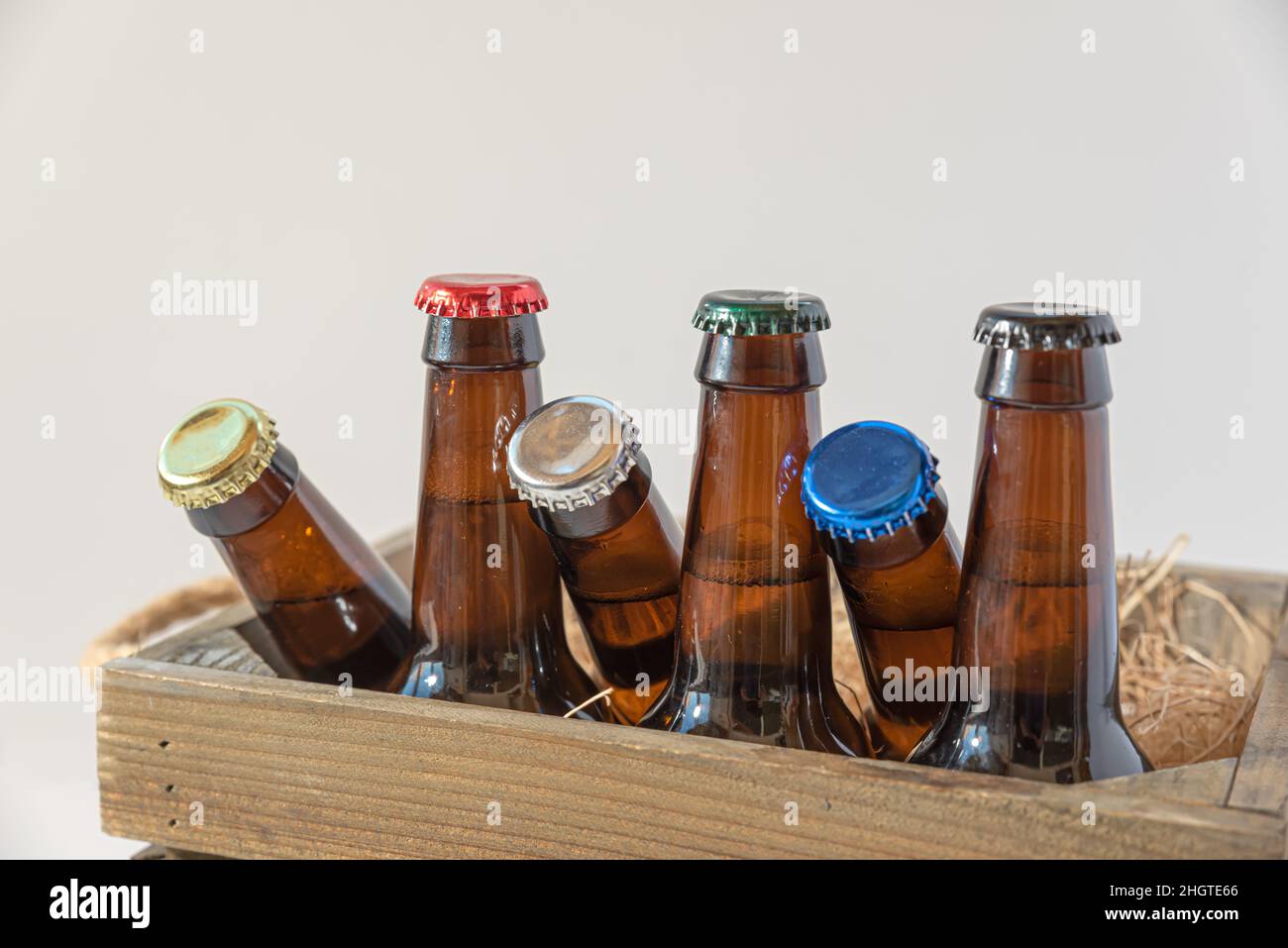 Boîte rustique en bois avec bouteilles de bière et assiettes colorées Banque D'Images