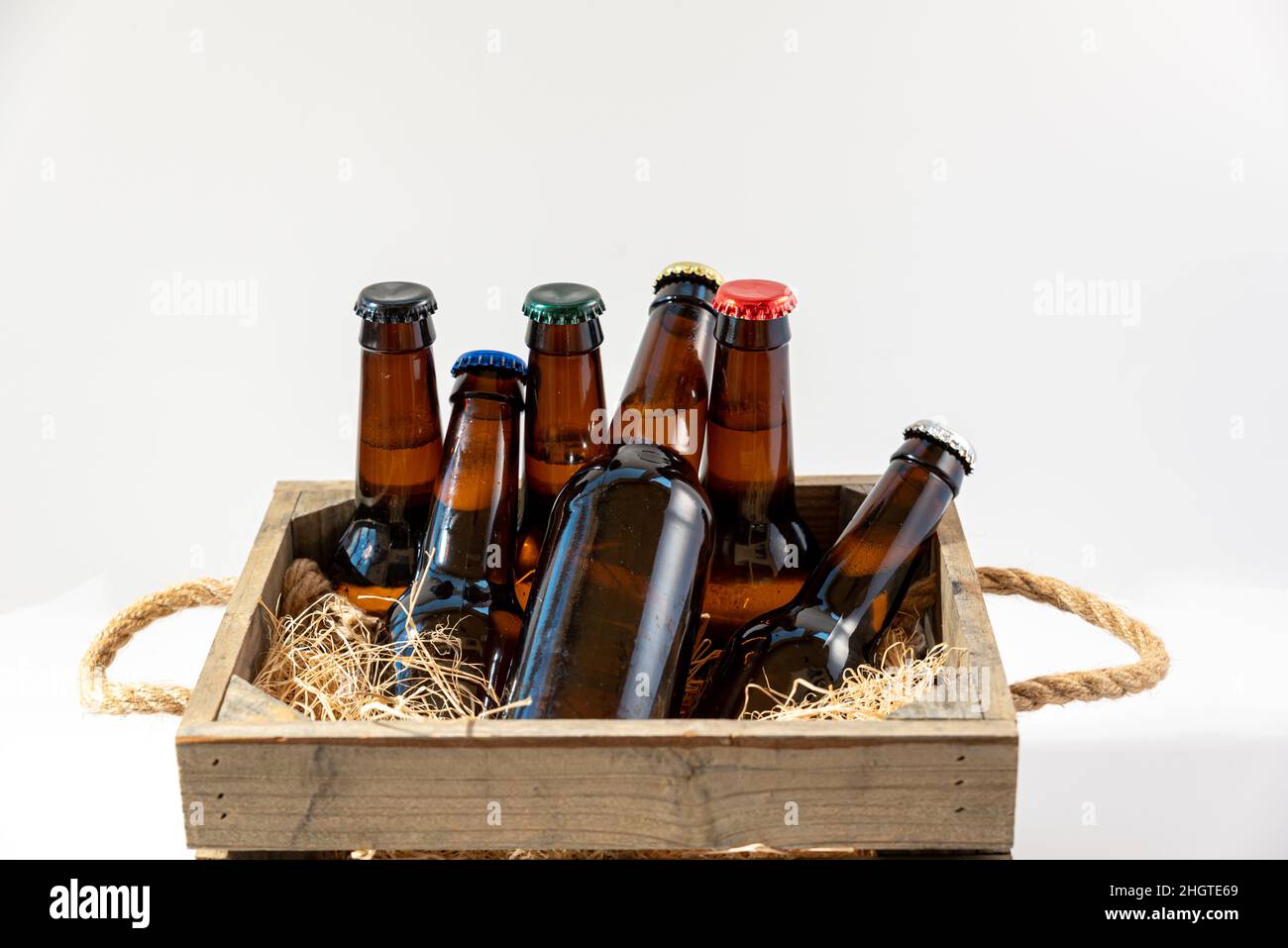Boîte rustique en bois avec bouteilles de bière et assiettes colorées Banque D'Images
