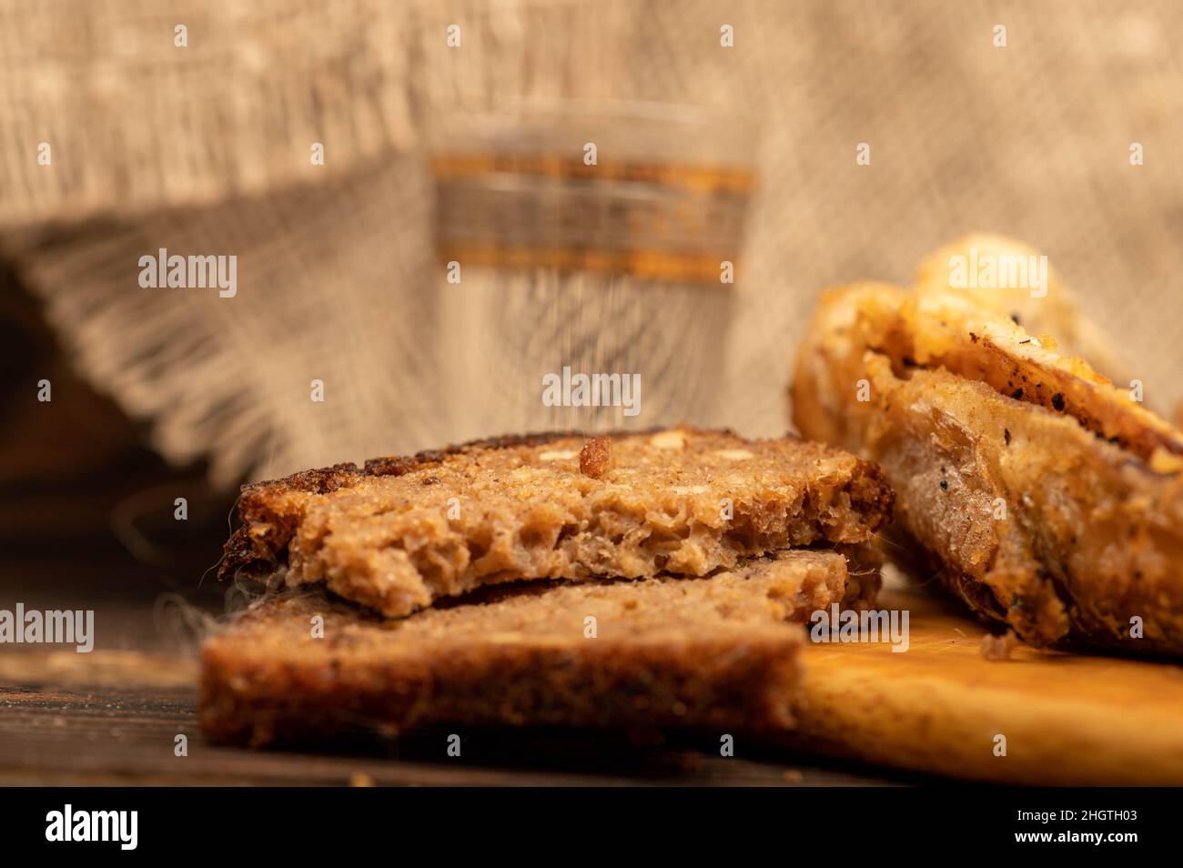 Un petit poisson frit sur une planche de bois, des morceaux de pain et un verre de vodka, gros plan, sélectif foyer Banque D'Images