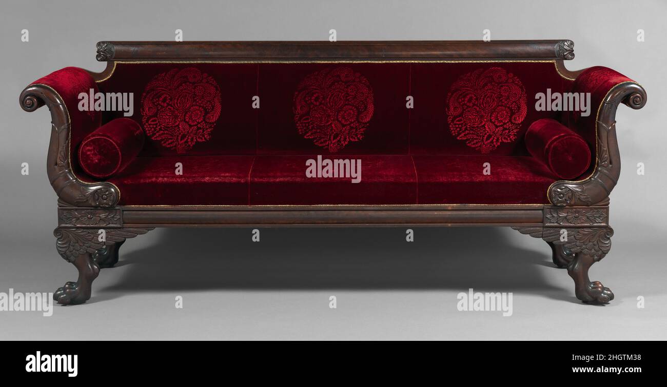 Canapé ca.1820 américain acquis en 1939, ce canapé superbement sculpté conserve encore sa couverture en velours de laine de couleur rouge bordeaux, qui sert de base à l'ameublement actuel (moderne).Il convient de noter la taille inhabituelle de laiton estampé riche, plutôt que le galloon tissé ou la série de clous à tête de laiton qui étaient habituels dans cette période.Canapé.Américain. CA.1820. Acajou.Fabriqué à Boston, Massachusetts, États-Unis Banque D'Images