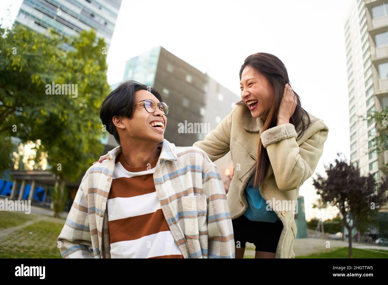 Un couple asiatique souriant s'est bien amusé et s'est regardé les uns les autres.Les jeunes amoureux font des vacances.Culture de la jeunesse et style de vie urbain. Banque D'Images