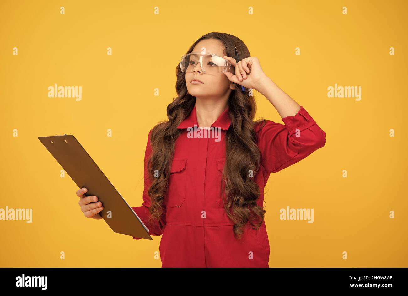 adolescente sérieuse fille dans des lunettes de protection de prendre des notes dans dossier avec des documents, étude Banque D'Images