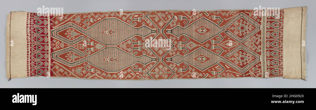Tissu cérémoniel 19th siècle IBAN-Dayak ce dix-neuvième siècle, rare tissu IBAN des peuples Dayak de Bornéo est en excellent état et présente une technique de pilih (trame supplémentaire) suprêmement bien exécutée sur une échelle inhabituellement grande.Le tissu est doté d'un arrière-plan décalé rouge et de motifs spectaculaires, en noir et blanc.Deux paires de créatures semblables à des lézard avec des languettes saillantes et des queues spiralées se font face, leurs bras et leurs jambes sont disposés de façon animée de chaque côté du corps comme si vous êtes prêt à frapper.Une double bordure en zigzag sépare leur ligne de symétrie.Des foli élaborés Banque D'Images
