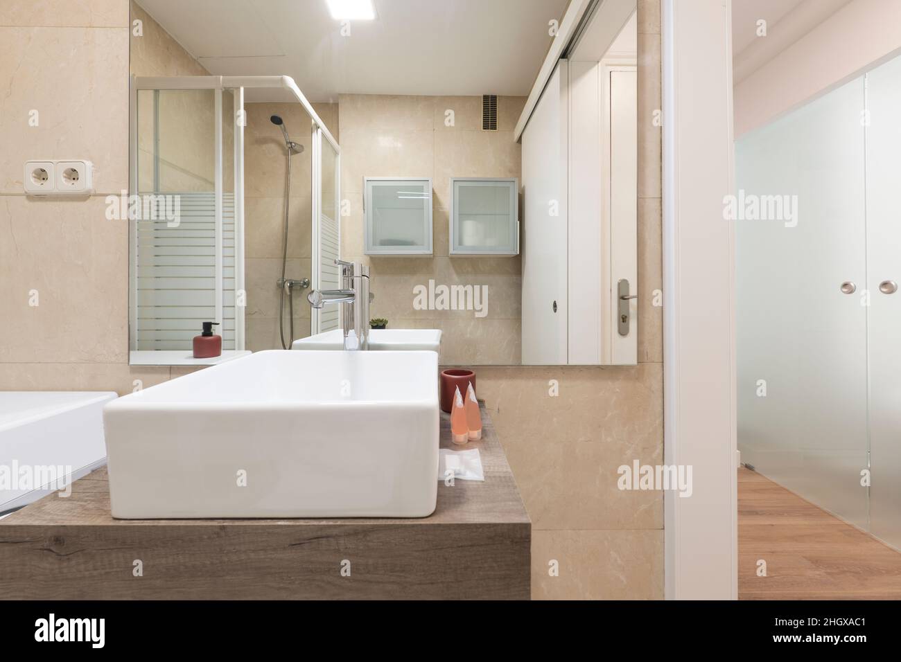 Salle de bains avec évier en porcelaine blanche, miroir sans cadre carré et porte-savon en marbre Banque D'Images