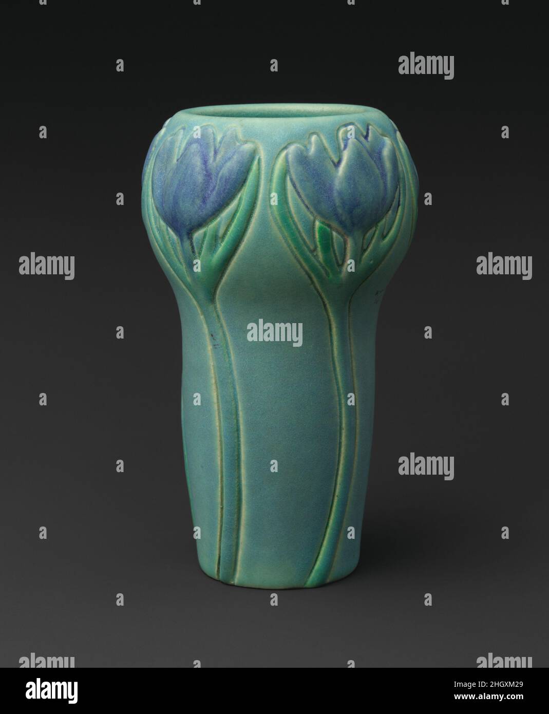 Vase avec crocuses 1902 conçu par Artus Van Briggle Artus Van Briggle a commencé sa carrière en céramique à la poterie de Rookwood, mais en raison de problèmes respiratoires, a déménagé au Colorado, où, avec sa femme Anna Van Briggle, il a établi sa propre poterie à Colorado Springs en 1901.Les Van Briggles et d'autres concepteurs ont produit des modèles à partir desquels des moules ont été fabriqués, et les vases ont ensuite été glissés sous plusieurs formes.Ils ont été particulièrement remarquables pour leurs glaçures dans des textures souples satinées dans des couleurs inhabituelles, parfois un ou plusieurs se combinent sur une seule pièce.Comme beaucoup d'artistes américains, Artus Van B. Banque D'Images
