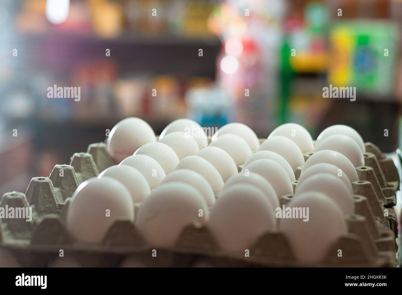 vue de plusieurs oeufs de poule blanche, placés dans un coffret en verre. vente d'oeufs dans une épicerie. oeufs riches en protéines d'albumine prêts à être vendus et con Banque D'Images