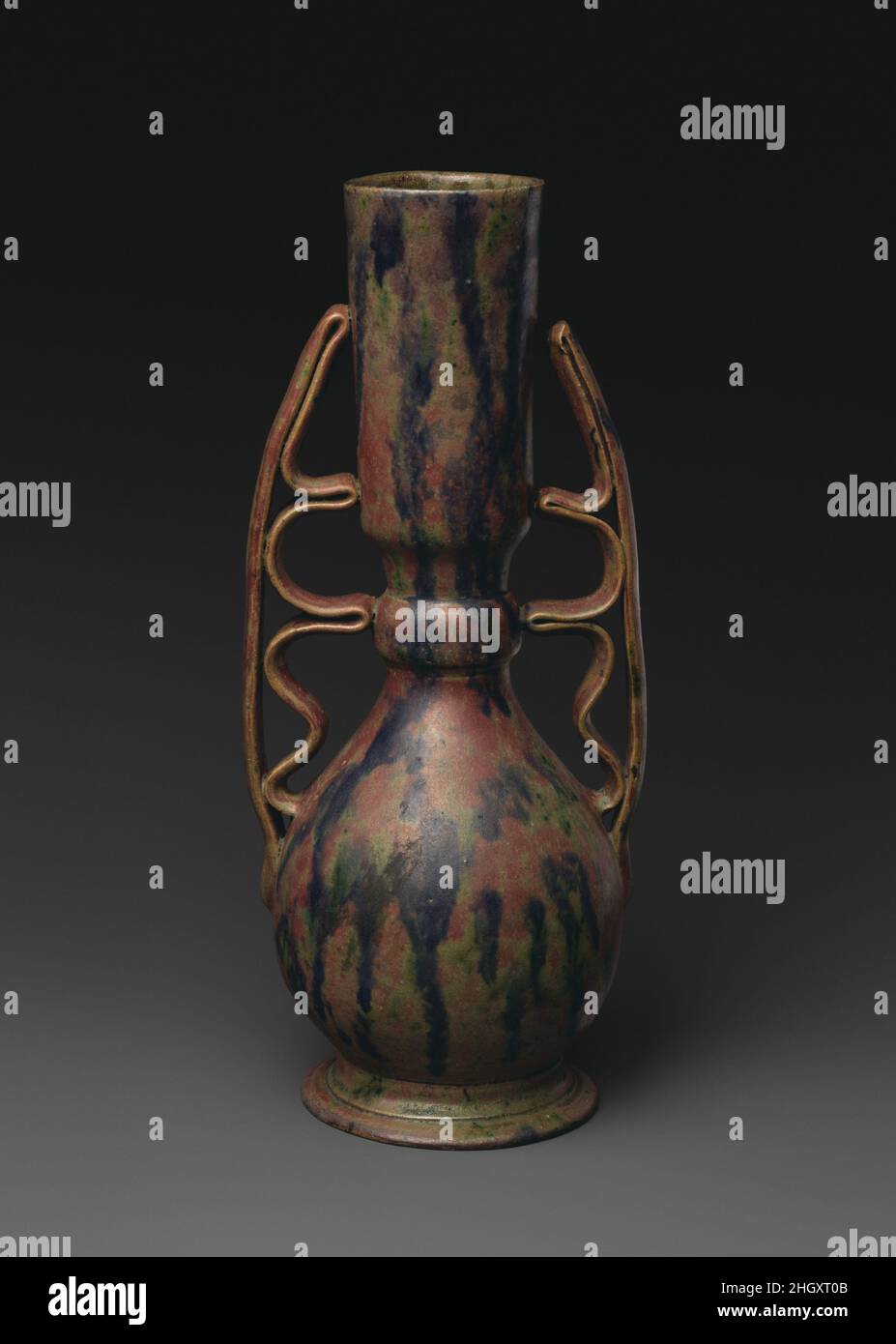 Vase ca.1897–1900 George E. OHR George OHR de Biloxi, Mississippi, était sans doute le potier artistique américain par excellence : il construisit son propre four, creusa de l'argile, jeta ses vaisseaux avec une extrême compétence sur la roue du potier pour galer la finesse, altéra ces formes, puis les couvra avec ses propres glaçures originales.Dans la forme et la décoration, ce sont essentiellement des objets expressionnistes abstraits, presque 50 ans avant la création de ce mouvement.Ces deux vases illustrent particulièrement bien la façon dont les poignées en ruban de la manne, flamboyante, de l’OHR transforment une forme traditionnelle de navire.Sur l'un, l'ajout de la serpentine Banque D'Images