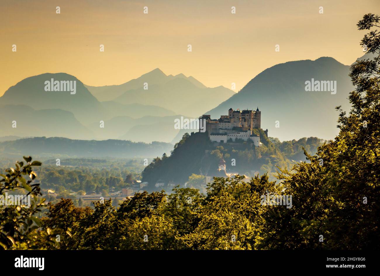 Forteresse de Hohensalzburg à une distance au sommet d'une colline surplombant Salzbourg, Autriche avec des couches de montagne douces pendant l'été Banque D'Images