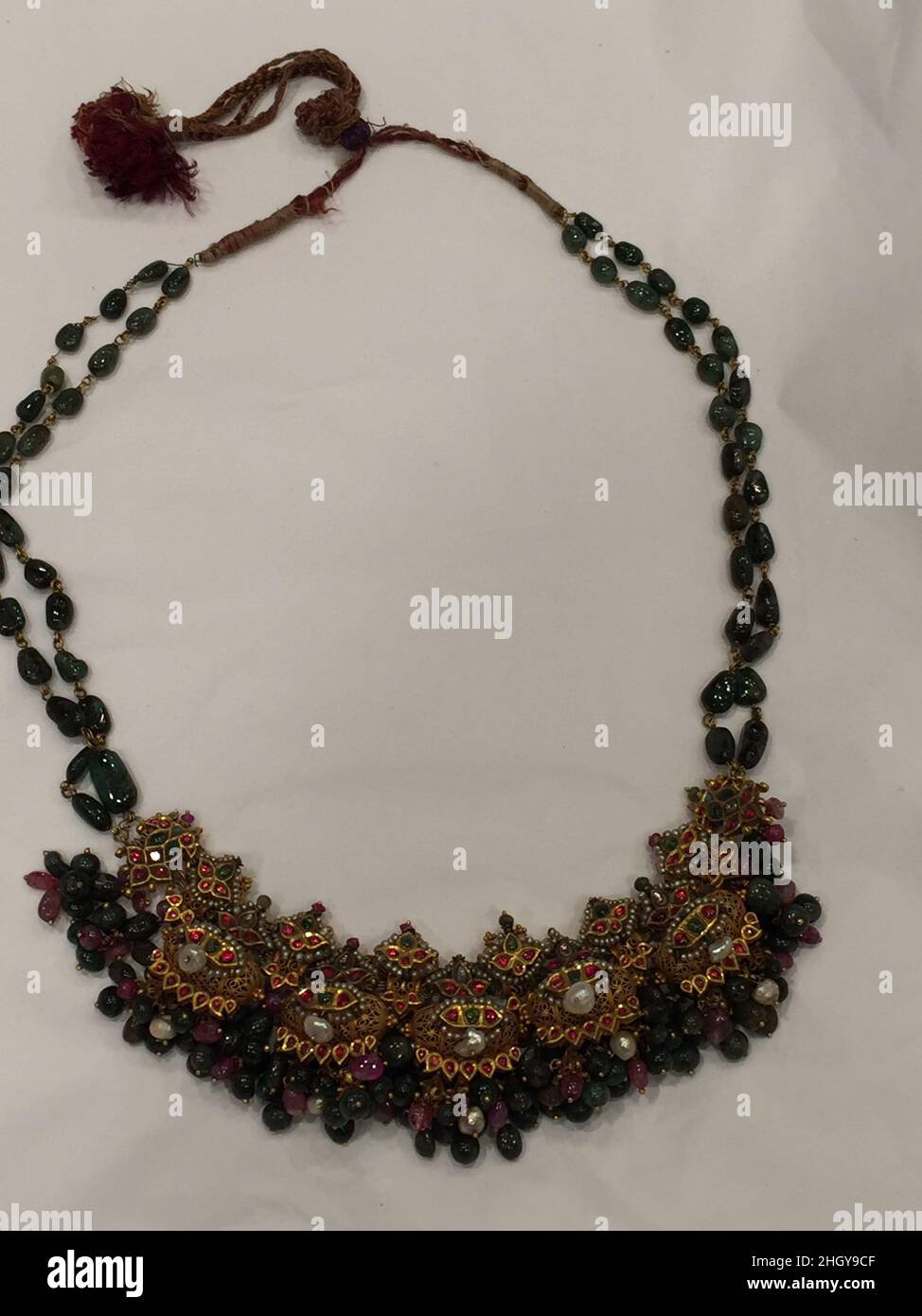 Collier 18th–19th siècle ce collier est composé de cinq pendentifs en tawiz ou en forme d'amulette, fabriqués en filigrane d'or et ornés de pierres précieuses et de perles.Des amas d'émeraudes rondes, de spinelles et de perles sont suspendus de chaque pendentif, donnant l'articulation à ce bijou avec le mouvement de l'utilisateur.Cette forme a été appelée kaliganthi, un collier donné à une mariée le jour de son mariage par ses beaux-parents.Collier 446750 Banque D'Images