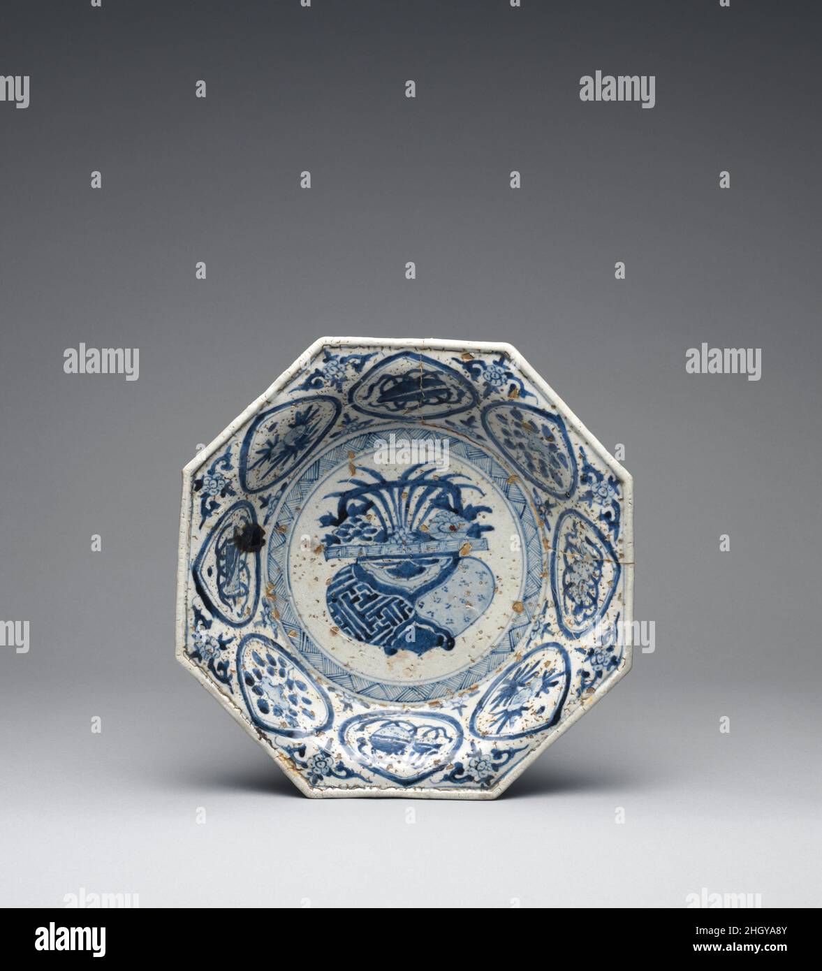 Plat octogonal peut-être 17th siècle peut-être Moyen-Orient, pour le marché d'exportation ce plat reflète la langue décorative des porcellains chinois des XVIe et XVIIe siècles, bien que la mauvaise qualité de sa fabrication indique qu'il n'a pas été fait en Chine,qui a excellé dans la production de tous les types de céramique.La palette bleue et blanche établie par les Chinois est devenue le symbole mondial de la porcelaine, et les motifs peints sur ce plat sont dérivés d'exemples chinois.Plat octogonal. Peut-être moyen-Orient, pour le marché d'exportation. Peut-être 17th siècle.Tout-petits Banque D'Images