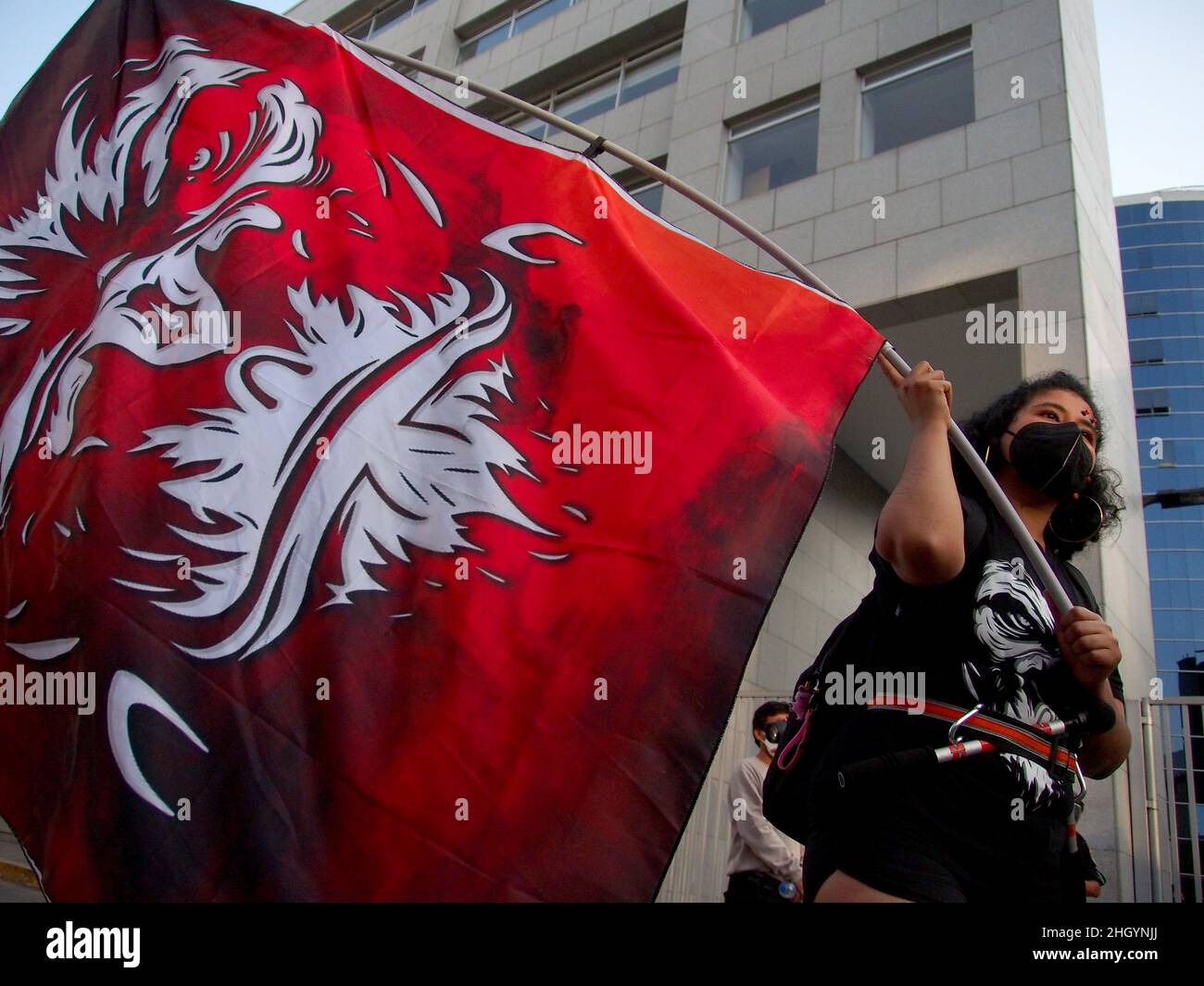Une jeune fille agite un grand drapeau rouge lorsque des dizaines de manifestants se rassemblent devant les bureaux de Repsol au Pérou pour protester contre la récente marée noire qui a causé une catastrophe écologique sur les côtes de Lima et El Callao.Le 15 janvier, au milieu de vagues anormales produites par l'éruption du volcan Tonga, plus de 6 000 barils de pétrole ont été déversés dans la mer à la raffinerie de la Pampille exploitée par Repsol, une compagnie pétrolière espagnole,L'une des plus grandes catastrophes écologiques des dernières décennies au Pérou. Banque D'Images