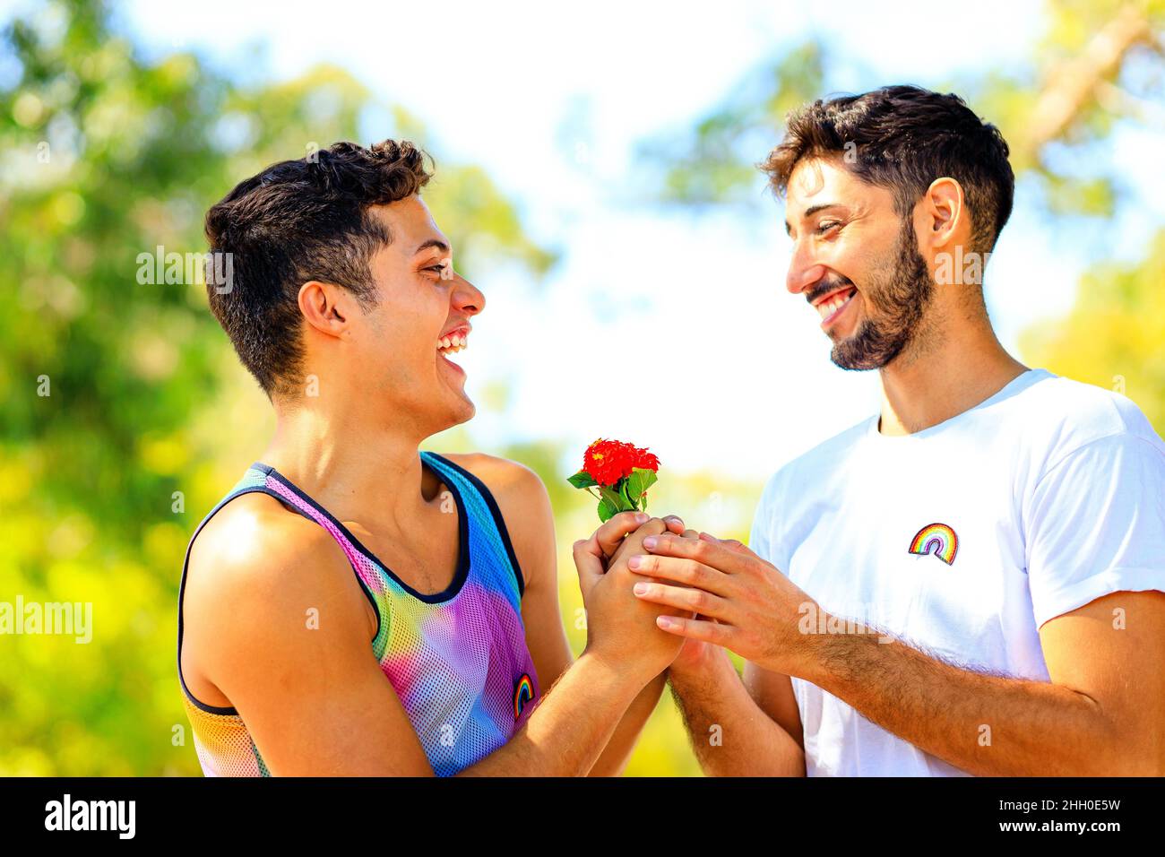 Un couple gay heureux passe du temps ensemble dans une journée ensoleillée dans un parc verdoyant Banque D'Images