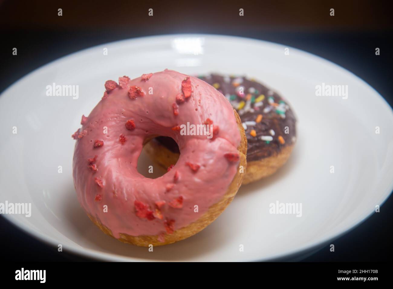 Beignets aux fraises et au chocolat sur une assiette blanche Banque D'Images
