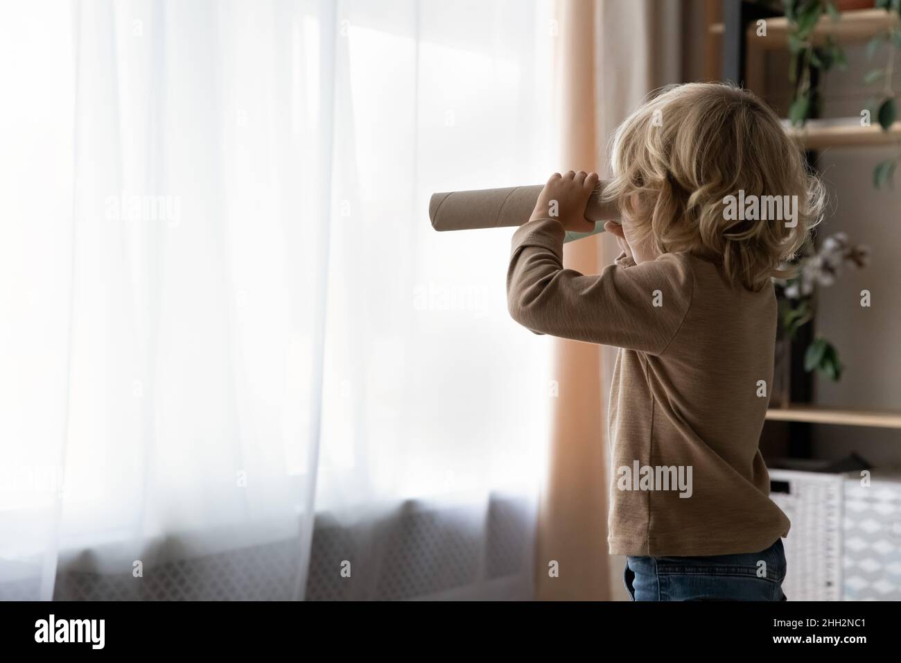 Joyeux adorable petit garçon jouant seul à la maison. Banque D'Images