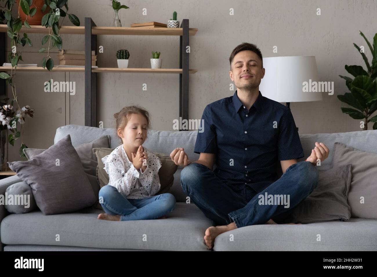 Conscient détendu deux générations famille faisant des exercices de respiration de yoga. Banque D'Images