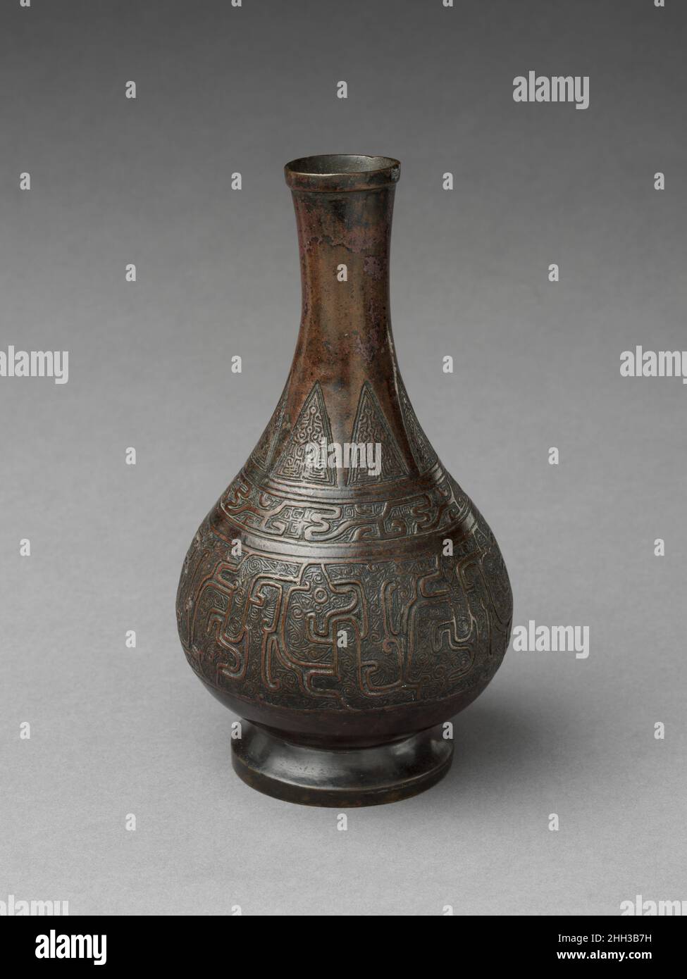 Vase à fleurs fin du 12th–13th siècle Chine ce vase doux présente une forme en céramique typique décorée de motifs en bronze de style archaïque.Sa forme ressemble à des celladon de qualité supérieure de la dynastie des Song du Sud.La large bande stylisée d'entrelacement de dragon qui entoure le ventre du navire est dérivée du siècle 5th–4th.Les modèles de bronze de la Colombie-Britannique, mais son traitement est beaucoup plus audacieux.Un tel décor peut également être trouvé sur une pièce excavée, ce qui aide à dater en toute sécurité ce navire au 12th ou 13th siècle.La combinaison réussie de la forme en céramique et du décor en bronze témoigne de la créativité Banque D'Images