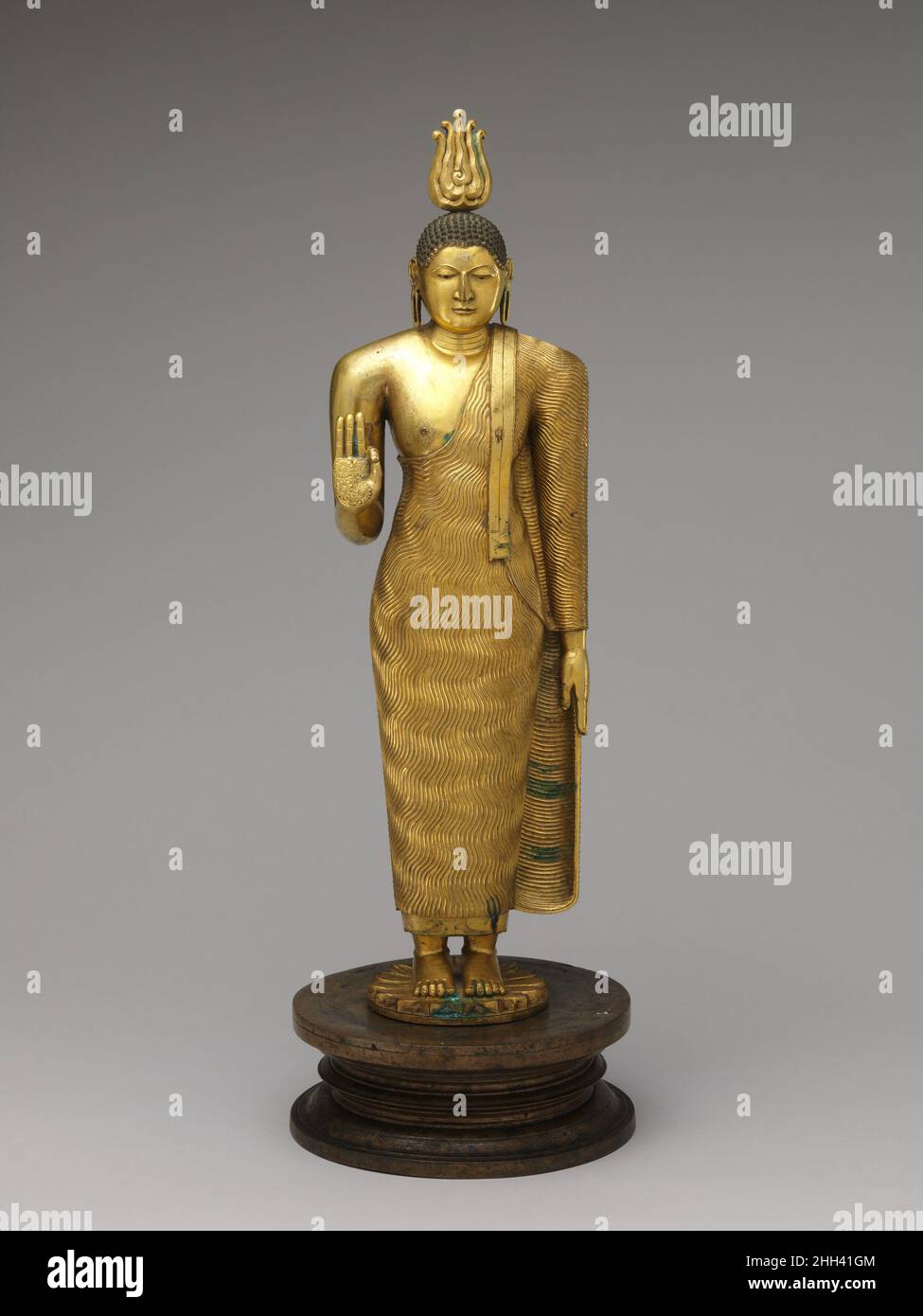Bouddha 18th siècle Sri Lanka, quartier de Kandy cette œuvre représente l'imagerie de Bouddha de la période de Kandyan à son meilleur.Le physique de la figure est robuste, et le visage entier manque de la douceur des caractéristiques trouvées dans les travaux moins importants de la période.Des marques de bonheur (lakshana) apparaissent ici, et le bras gauche abaissé est une convention qui a persisté tout au long de la période de Kandyan.Bouddha.Sri Lanka, district de Kandy.18th siècle.Alliage de cuivre doré.Période de Kandyan.Sculpture Banque D'Images