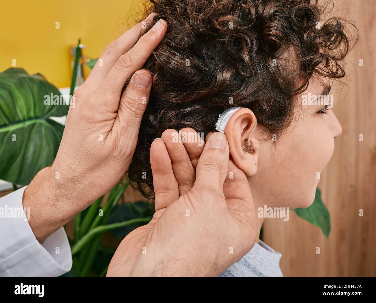 Installation d'une prothèse auditive sur l'oreille d'un enfant masculin dans une clinique d'audition, vue rapprochée, vue latérale.Traitement de la surdité, solutions auditives pour les enfants Banque D'Images