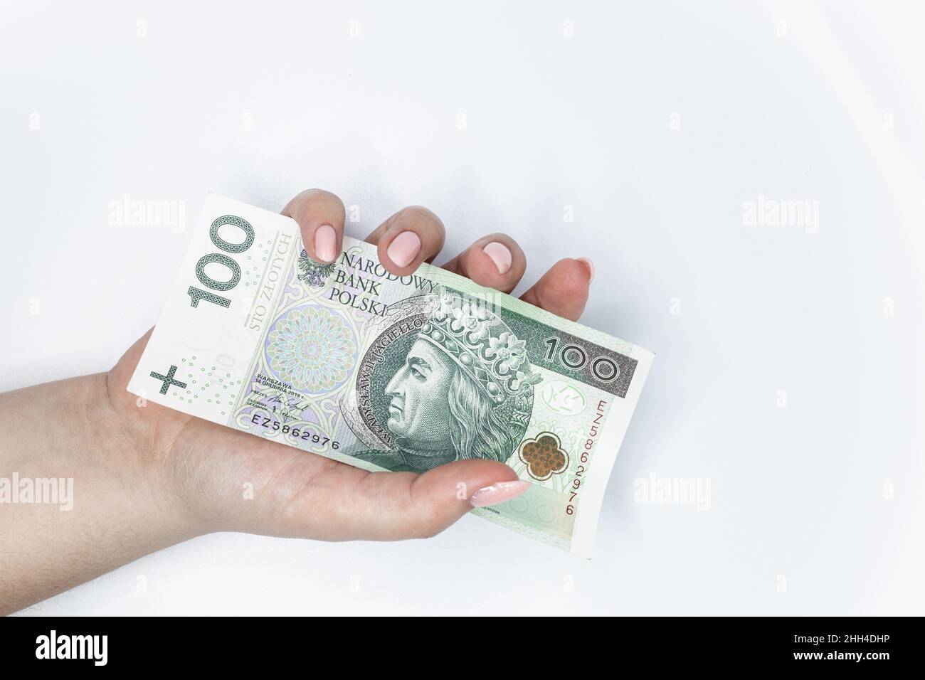Cent zloty - billet de banque polonais.La monnaie polonaise tient dans la main sur fond blanc Banque D'Images