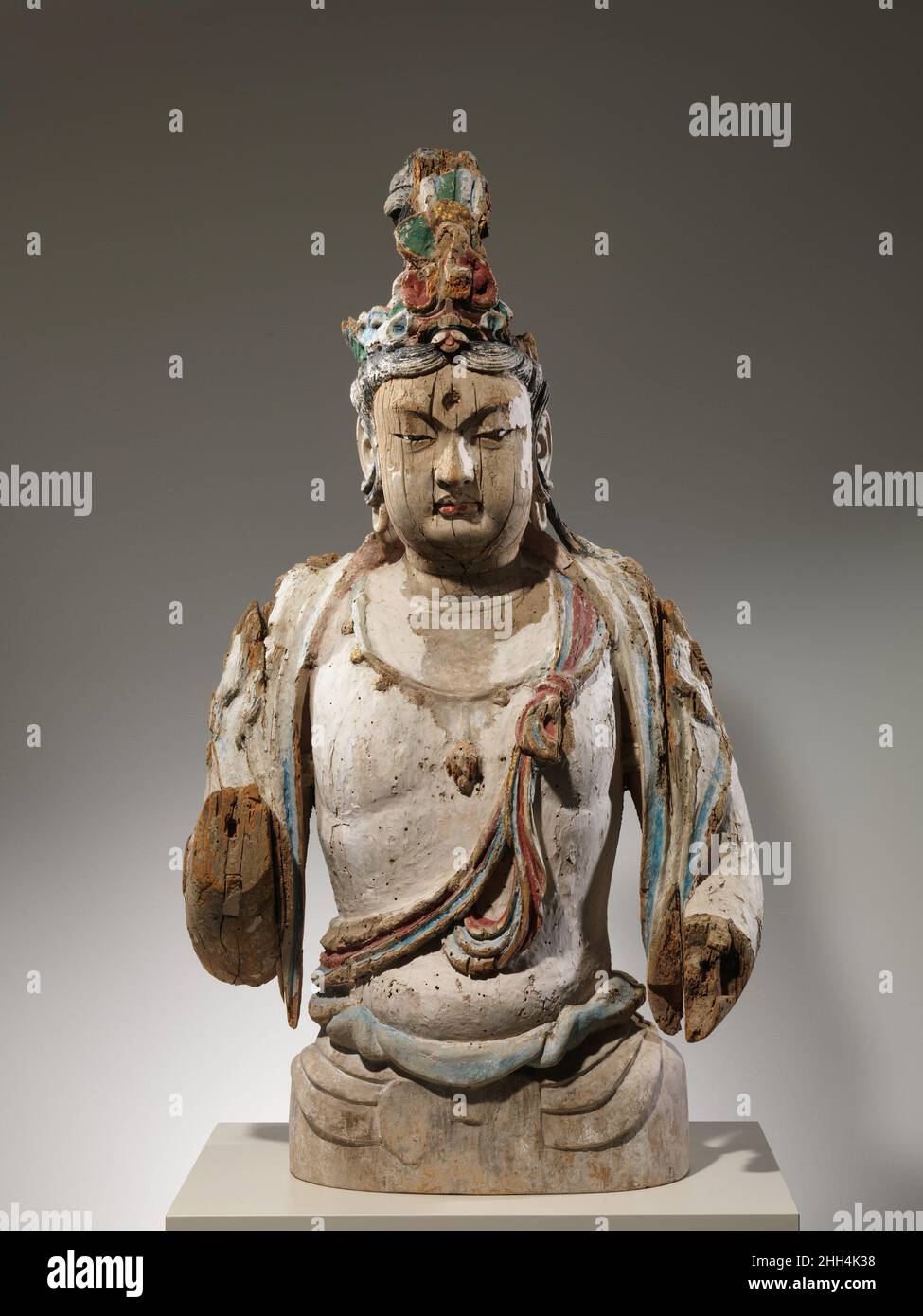 Attendant Bodhisattva 10th–11th siècle Chine cette sculpture d'un accompagnateur bodhisattva faisait probablement partie d'un triptyque colossal montrant un Bouddha flanqué de deux de ces figures.Il est fait de saule, un matériau qui a souvent été utilisé dans le nord pour la construction de la sculpture bouddhiste, et a été peint une fois de couleurs vives.Le sens du volume du corps, le rendu soigneux des tresses qui tombent le long des épaules et le foulard attaché à la poitrine sont des caractéristiques typiques de la statuaire bouddhiste datant des dixième et onzième siècles.Gardien Bodhisattva.Chine.10th–11th siècle.Bois (saule) W Banque D'Images