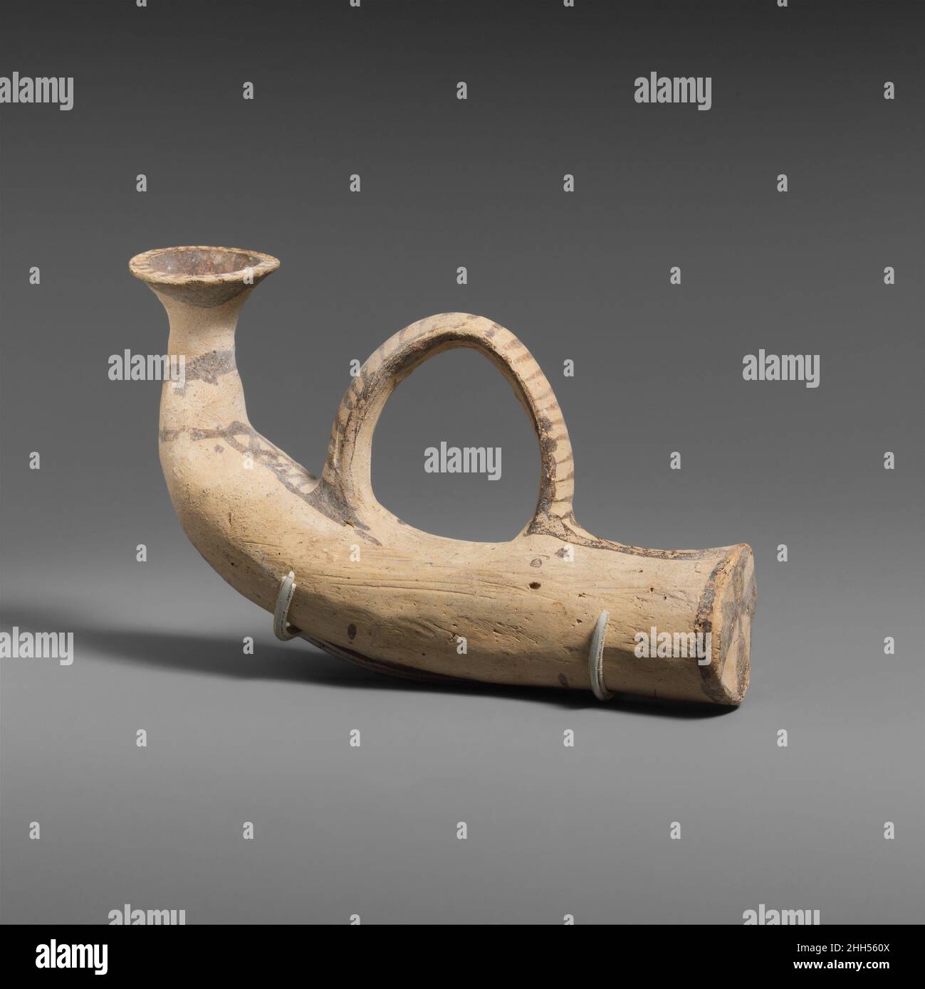 Vase en terre cuite en forme de corne 1050–950 C.-B. Cypriote une corne d'animal se prête naturellement pour l'utilisation dans la boisson et le versement des libations, la version en argile conserve des détails tels que l'embout buccal articulé et la sangle, ici servant de poignée.Vase en terre cuite en forme de corne 240668 Banque D'Images