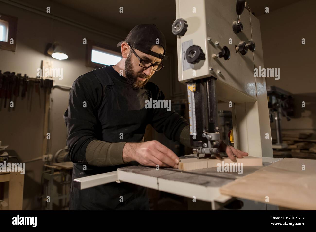 Travailleur du bois travaillant sur la scie à ruban en atelier Banque D'Images