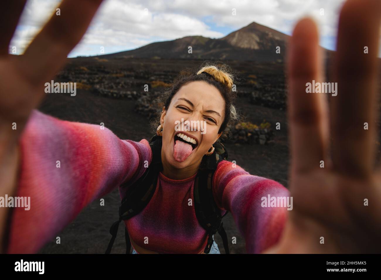 Bonne femme qui colle à la langue et prend le selfie avec le paysage en arrière-plan Banque D'Images