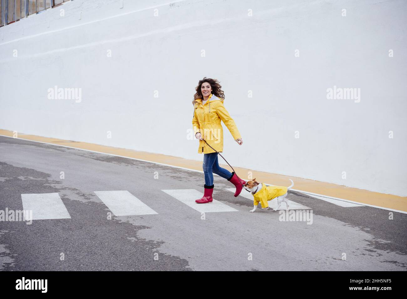 Une femme ludique qui court avec un chien sur un tableau de bord Banque D'Images