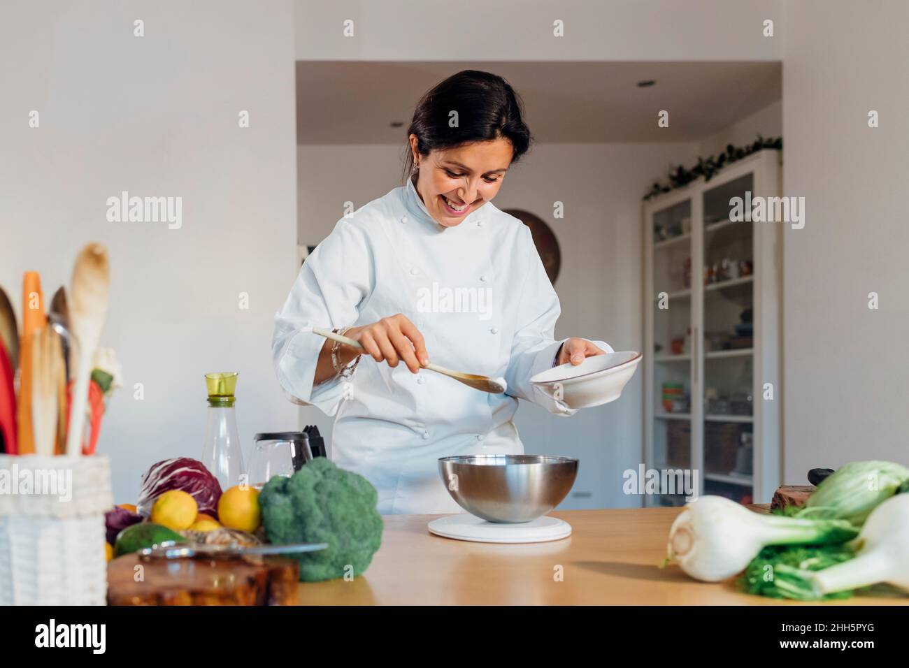 Un chef souriant prépare des plats dans la cuisine à la maison Photo Stock  - Alamy
