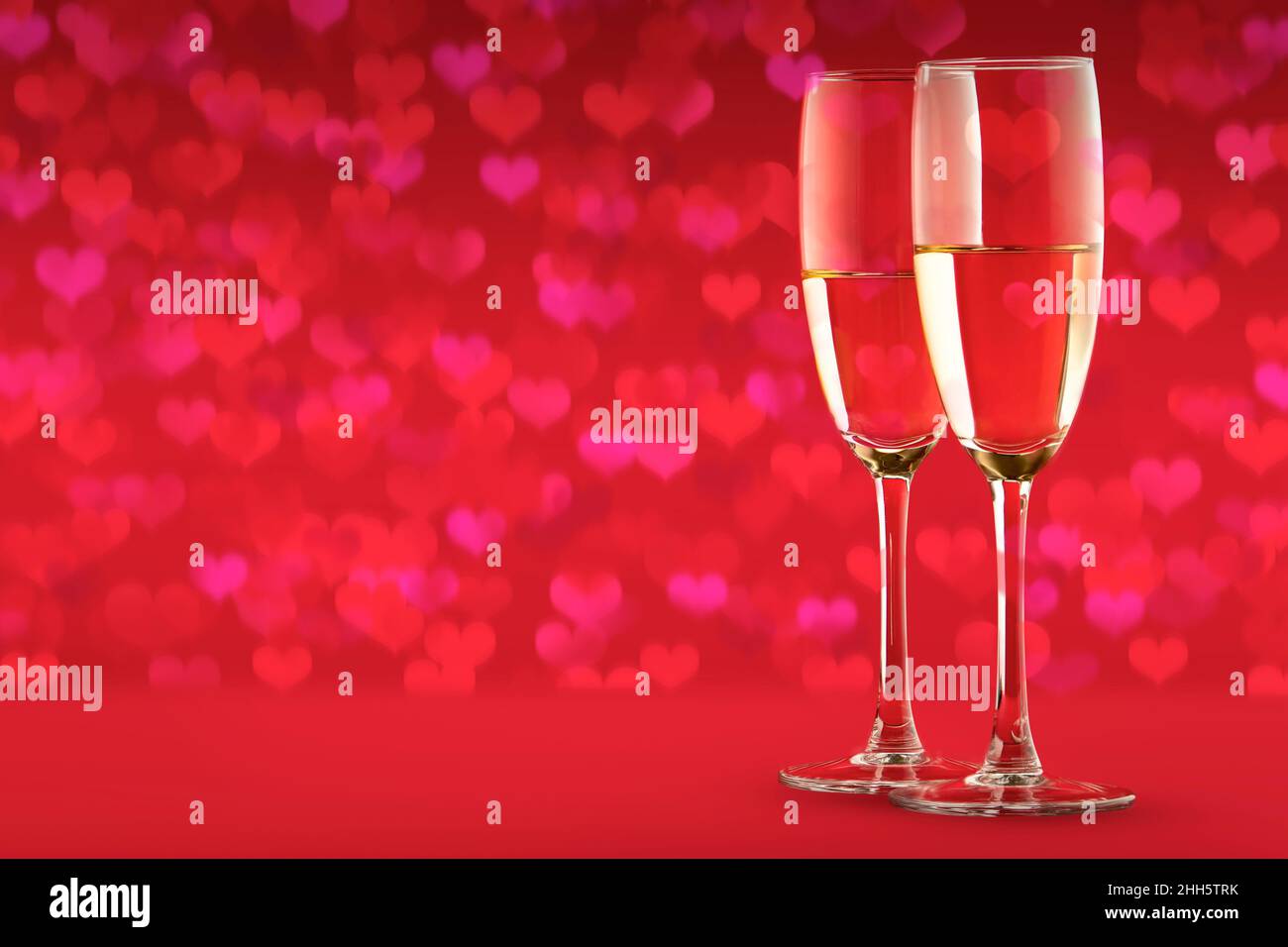 Deux verres avec un verre de champagne sur fond rouge de coeurs. Un symbole  de célébration, d'amour ou un dîner festif en l'honneur de la  Saint-Valentin Photo Stock - Alamy