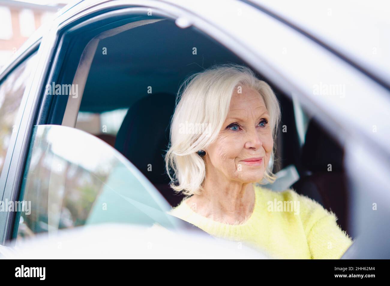 Femme âgée souriante avec voiture à cheveux blancs Banque D'Images