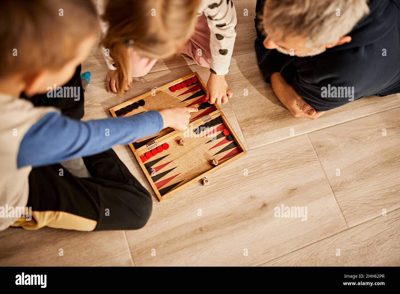 Enfants jouant au backgammon avec grand-père à la maison Banque D'Images