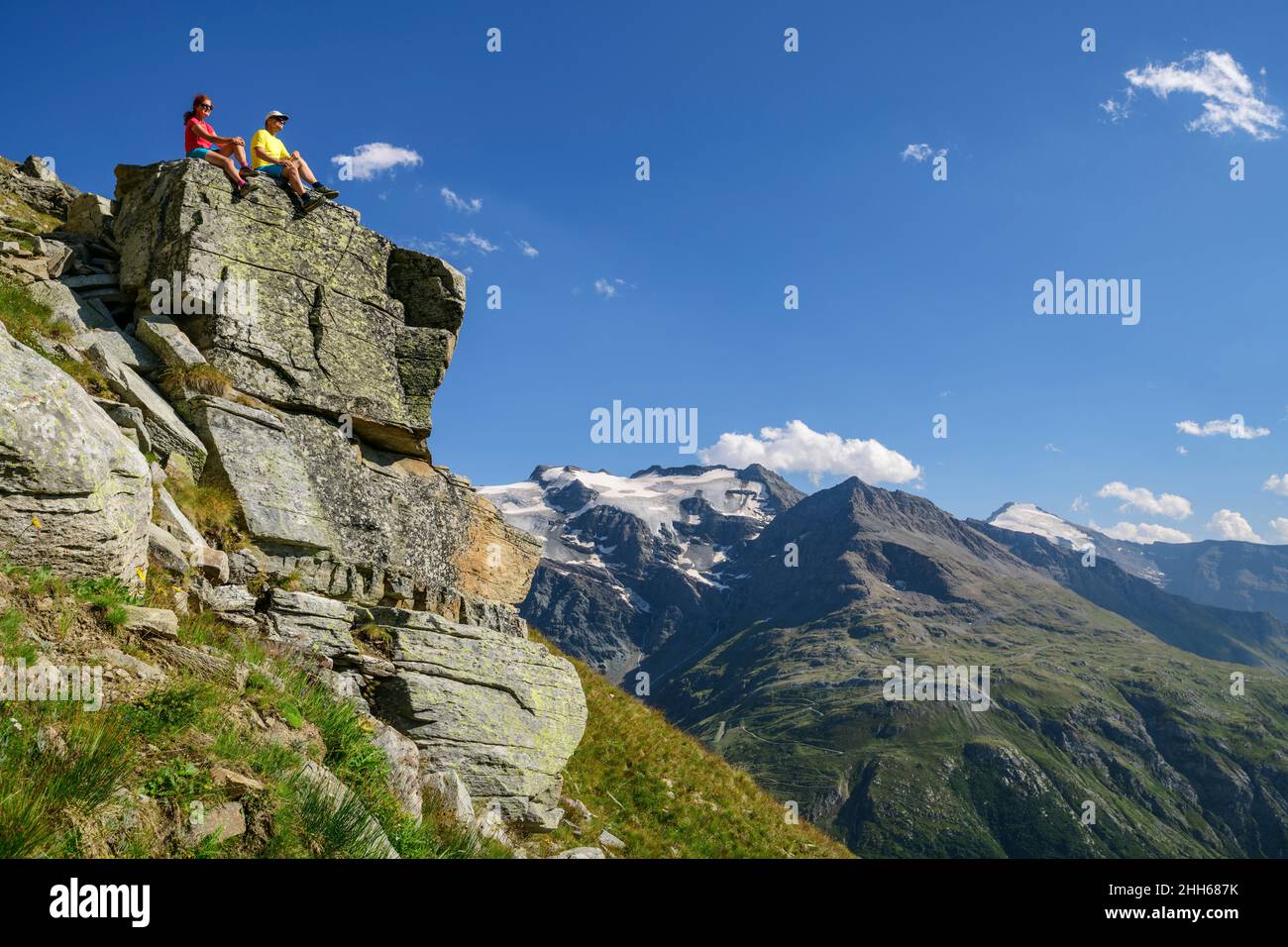 Randonneurs assis au sommet de la falaise, au soleil du massif de la Vanoise, Parc National de la Vanoise, France Banque D'Images