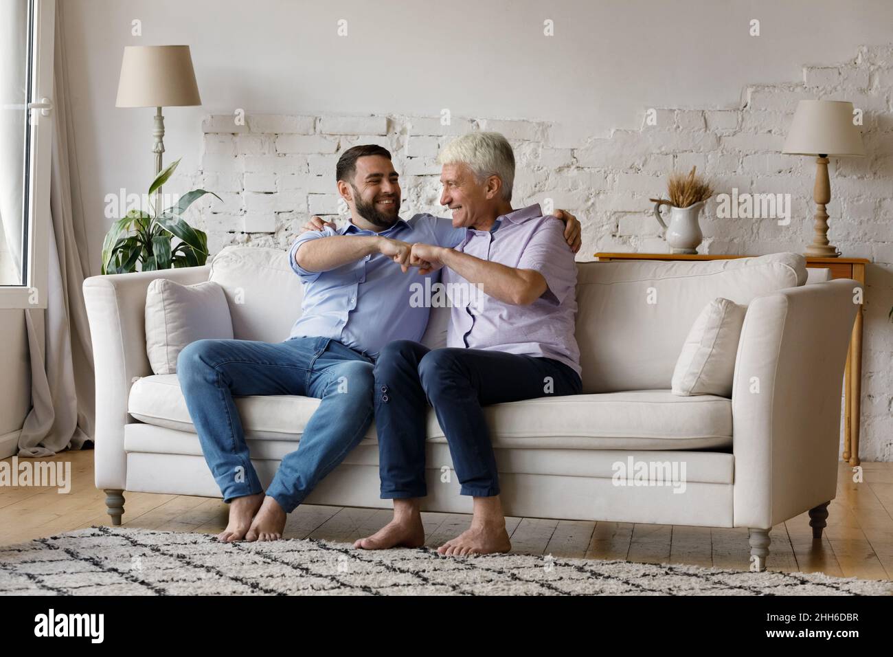 Un père aîné et un adulte qui grognup leur donnent une bosse de poing Banque D'Images