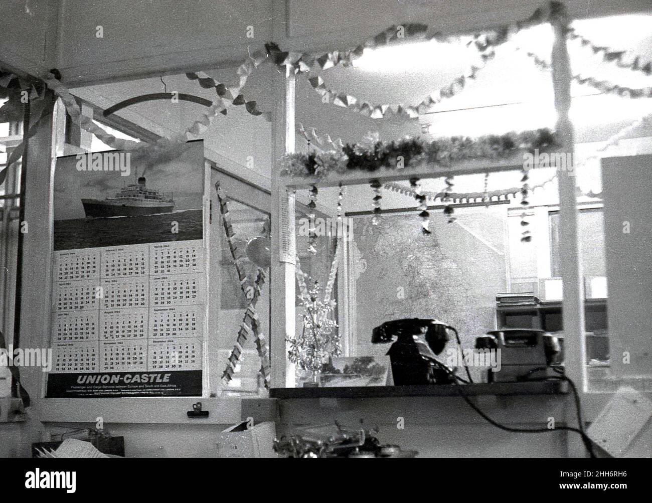 1964, historique, Import/export compagnie de fret, montrant un syndicat-château calendrier, une carte du monde et des téléphones de l'époque sur le comptoir, Angleterre, Royaume-Uni.Union-Castle était l'une des principales compagnies de vapeur de l'époque, fournissant des services de passagers et de fret entre l'Europe et l'Afrique du Sud et de l'est, Banque D'Images