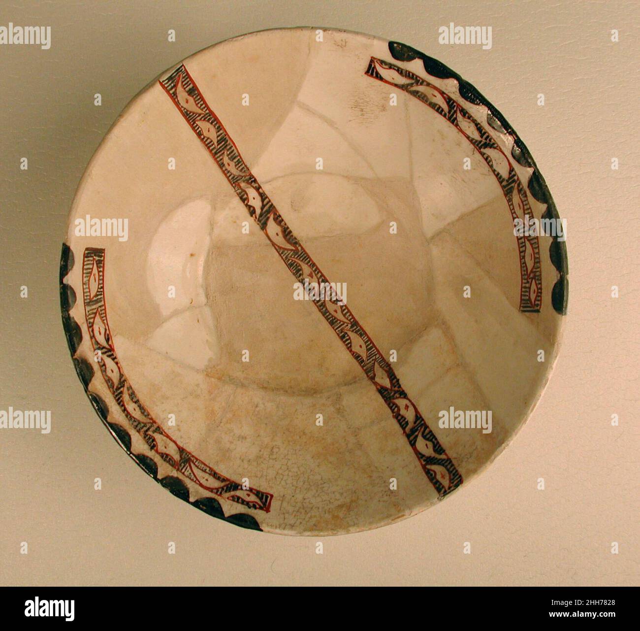 Bol 10th siècle ce bol présente le même sol blanc brillant et la même retenue de décoration que les fines pièces d'inscriptional de Nishapur.Le dispositif de composition quelque peu audacieux d'une bande, qui comporte généralement une inscription, mais vu ici avec une décoration abstraite, qui se poursuit au centre d'un bord à l'autre, est également vu dans d'autres articles de Nishapur.Bol 449432 Banque D'Images