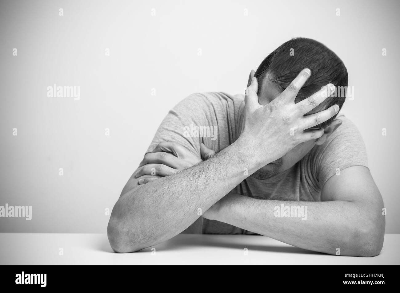 Homme sans-abri addicte de drogue et d'alcool assis seul et déprimé à la maison se sentant anxieux et solitaire, social documentaire concept noir et blanc Banque D'Images