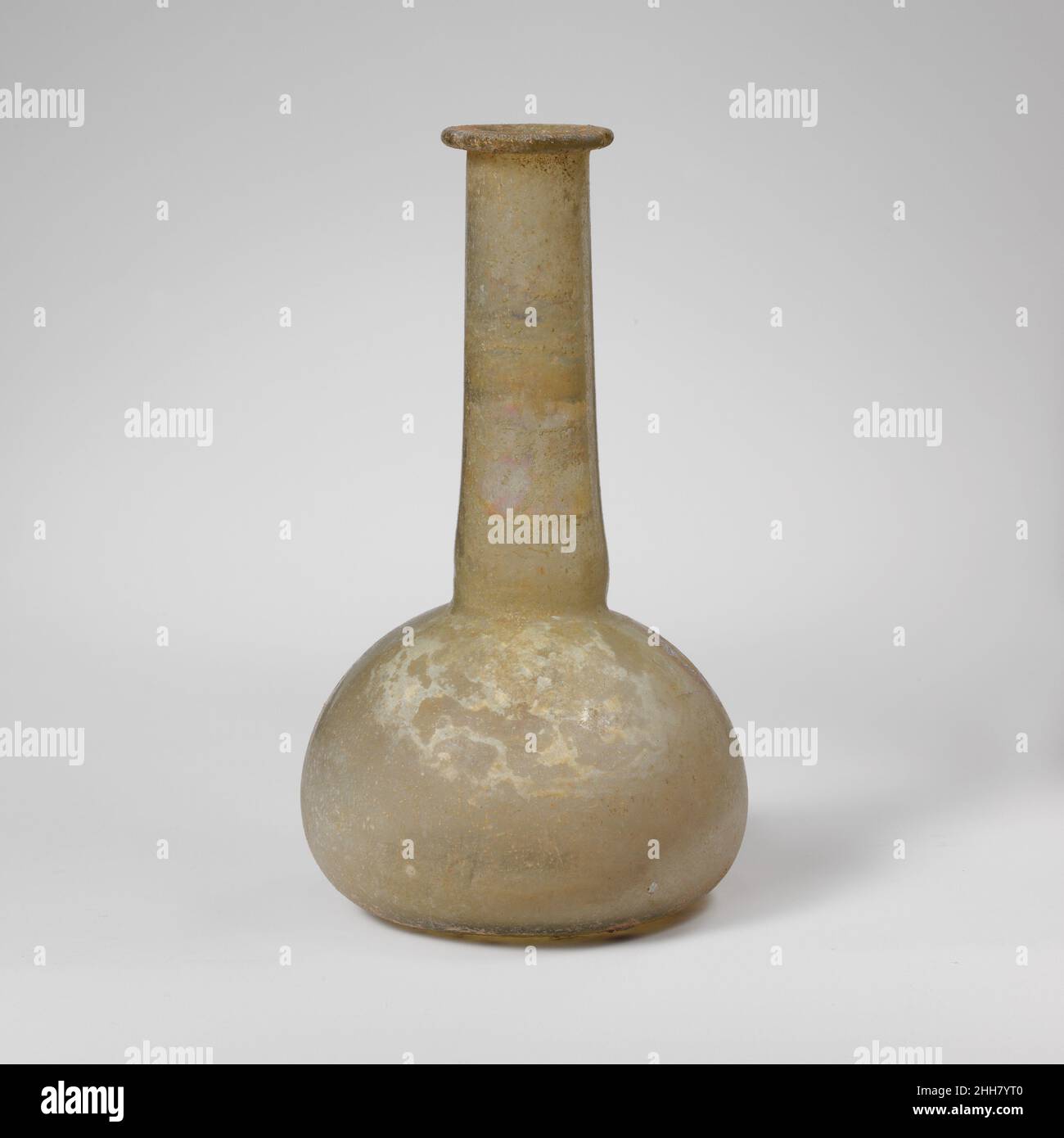 Flacon de parfum en verre 2nd–3rd Century A.D. Roman translucide vert jaunâtre pâle.rebord replié, sur et dans, aplati sur le dessus et dans la bouche; col grand, cylindrique, extensible vers le bas et outillagé autour de la base; corps squameux;Fond plat. Intact, sauf pour une fissure et une petite puce dans le rebord et de plus grandes fissures autour du corps rayonnant du petit trou; des bulles de piquer; le morcellement, avec des taches de piqûres et des intempéries irisées.Flacon de parfum en verre.Romain.2nd–3rd siècle A.D..Verre ; soufflé.Moyen ou tardif.Verre Banque D'Images